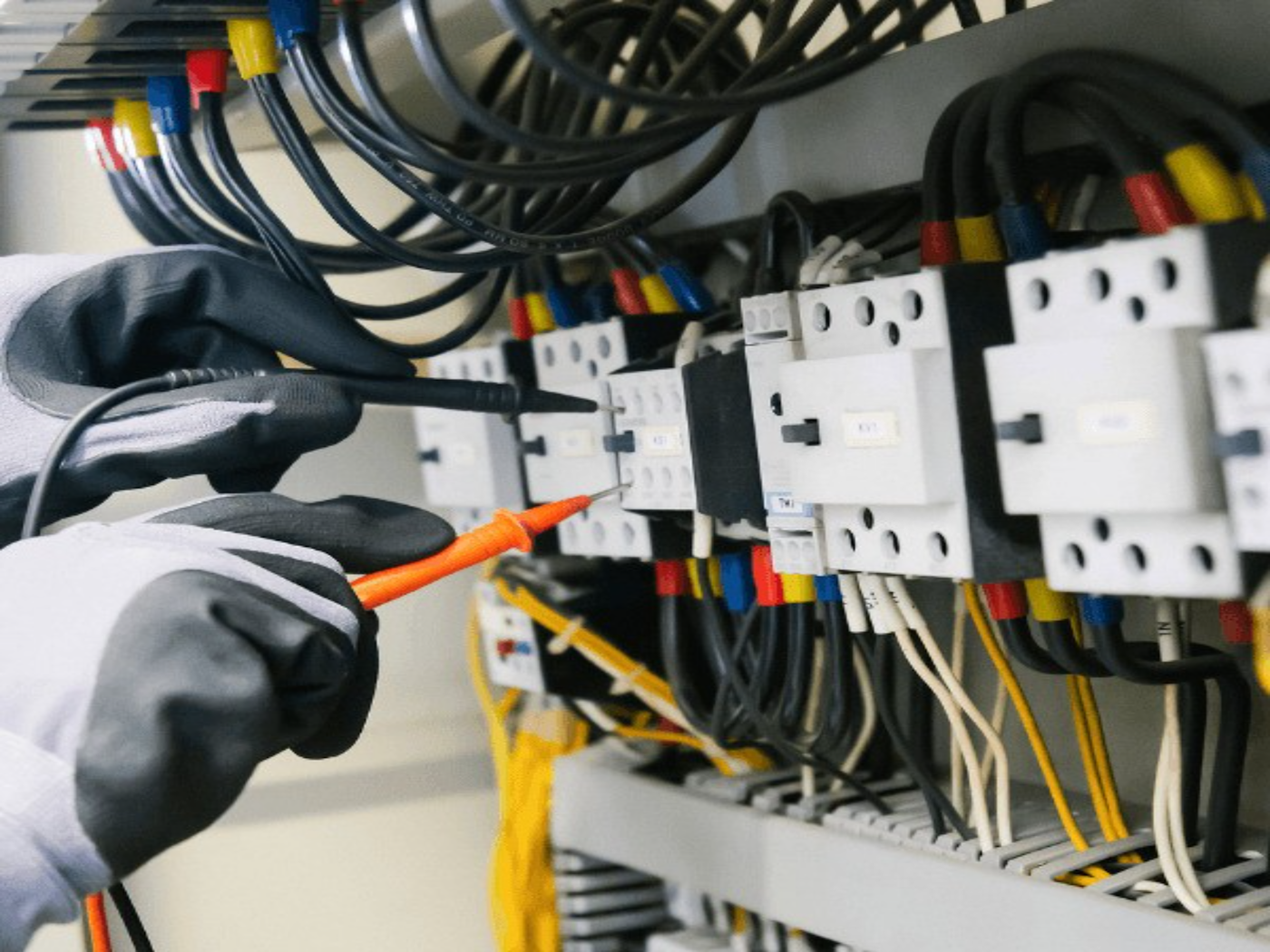Eletricista trabalhando em painel elétrico