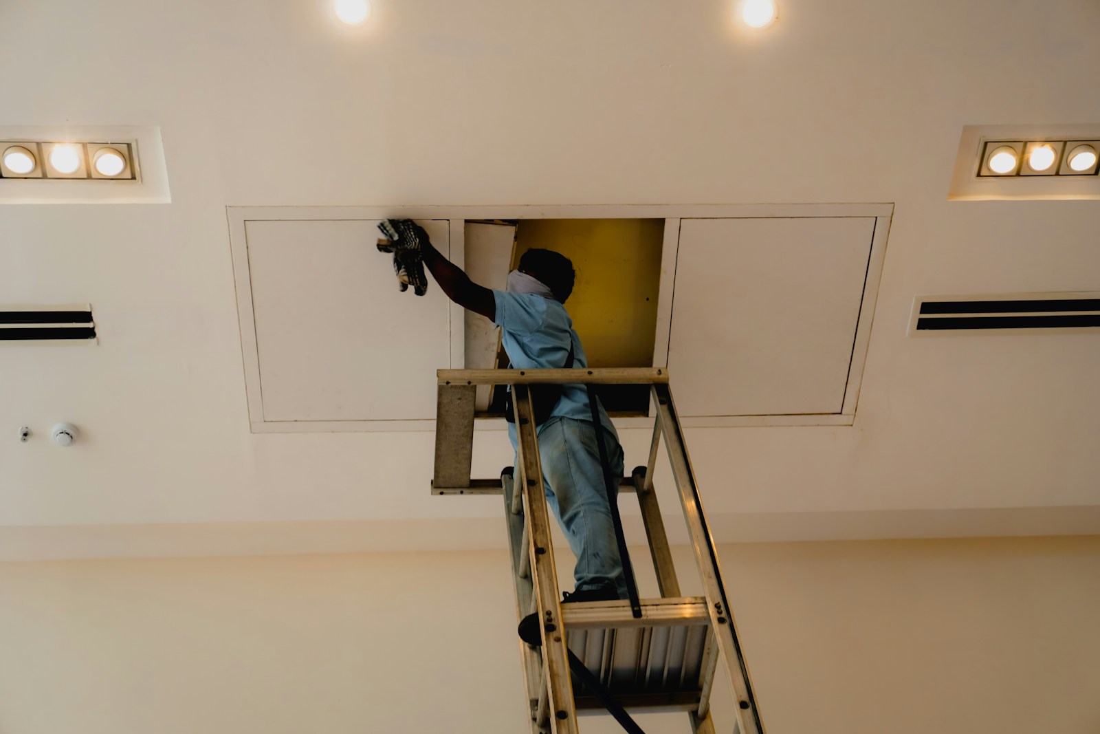 Profissional trabalhando em painel de acesso no teto
