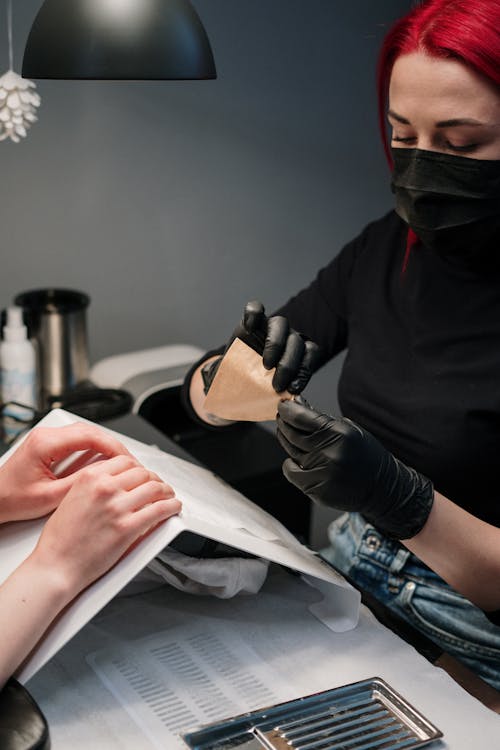 Manicure realizando esmaltação profissional