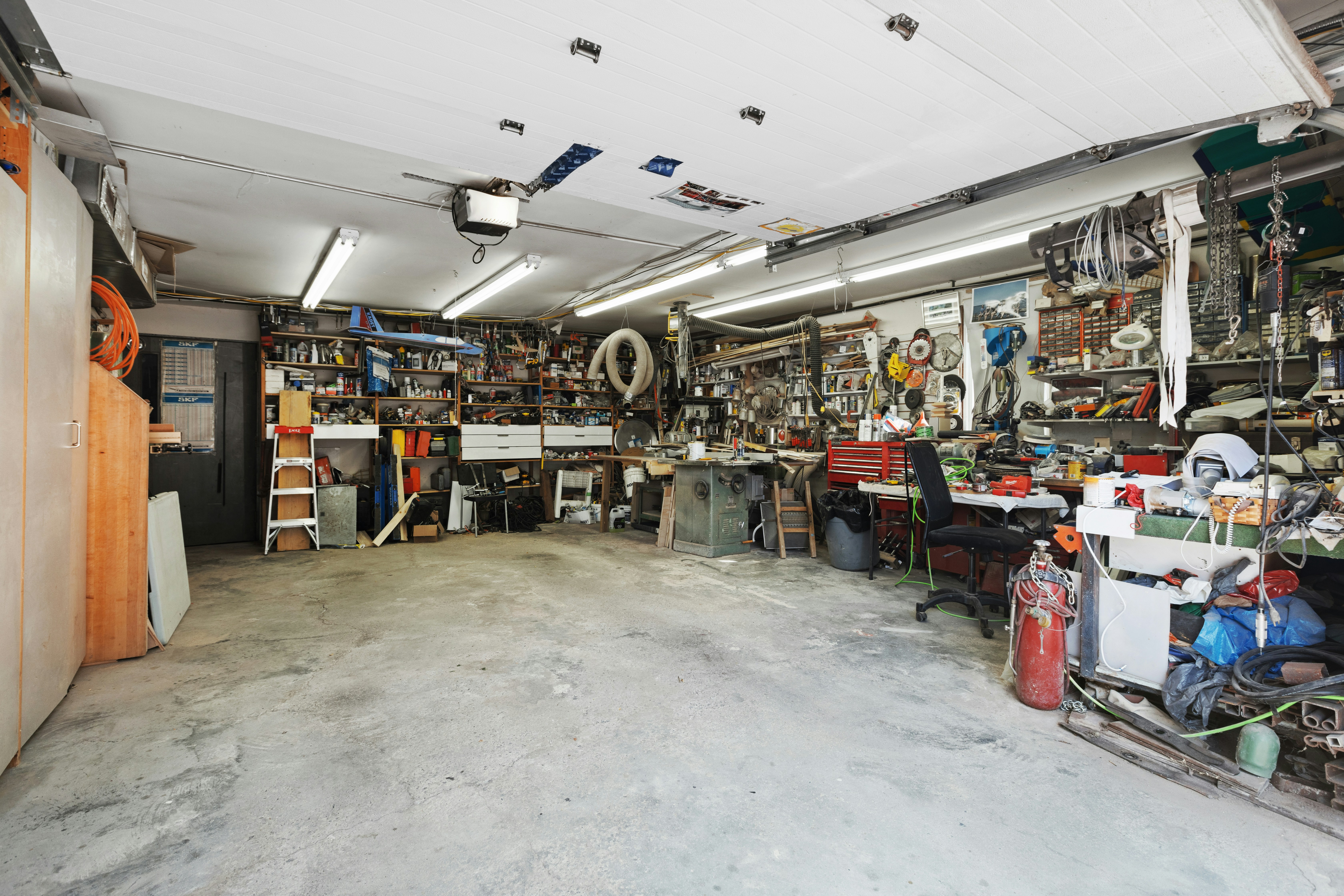 Garagem desorganizada com ferramentas e peças espalhadas