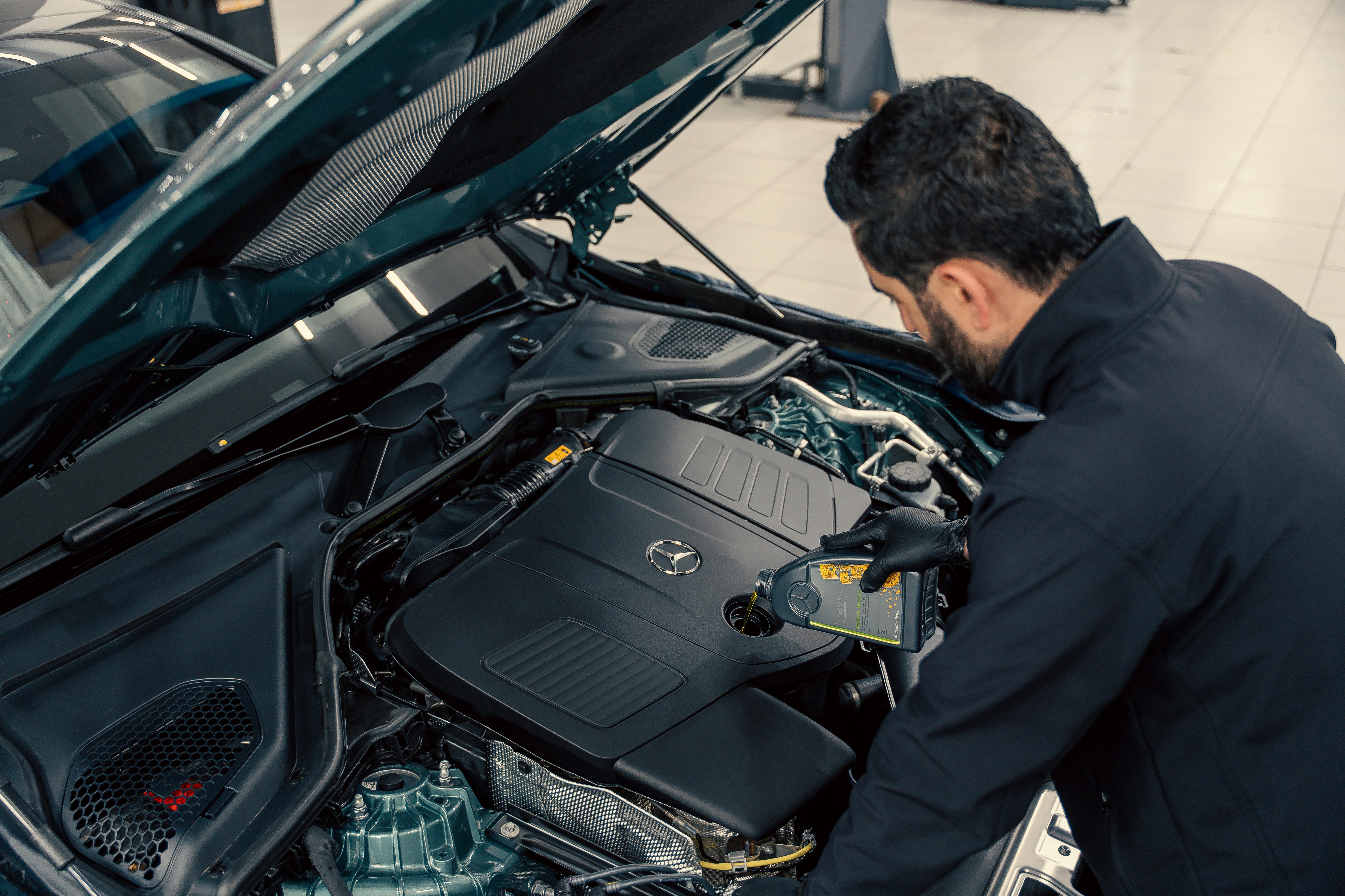 Mecânico inspecionando motor de carro em oficina profissional