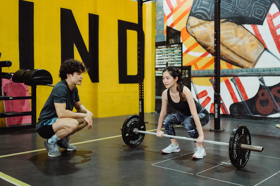 Personal trainer em academia com aluno