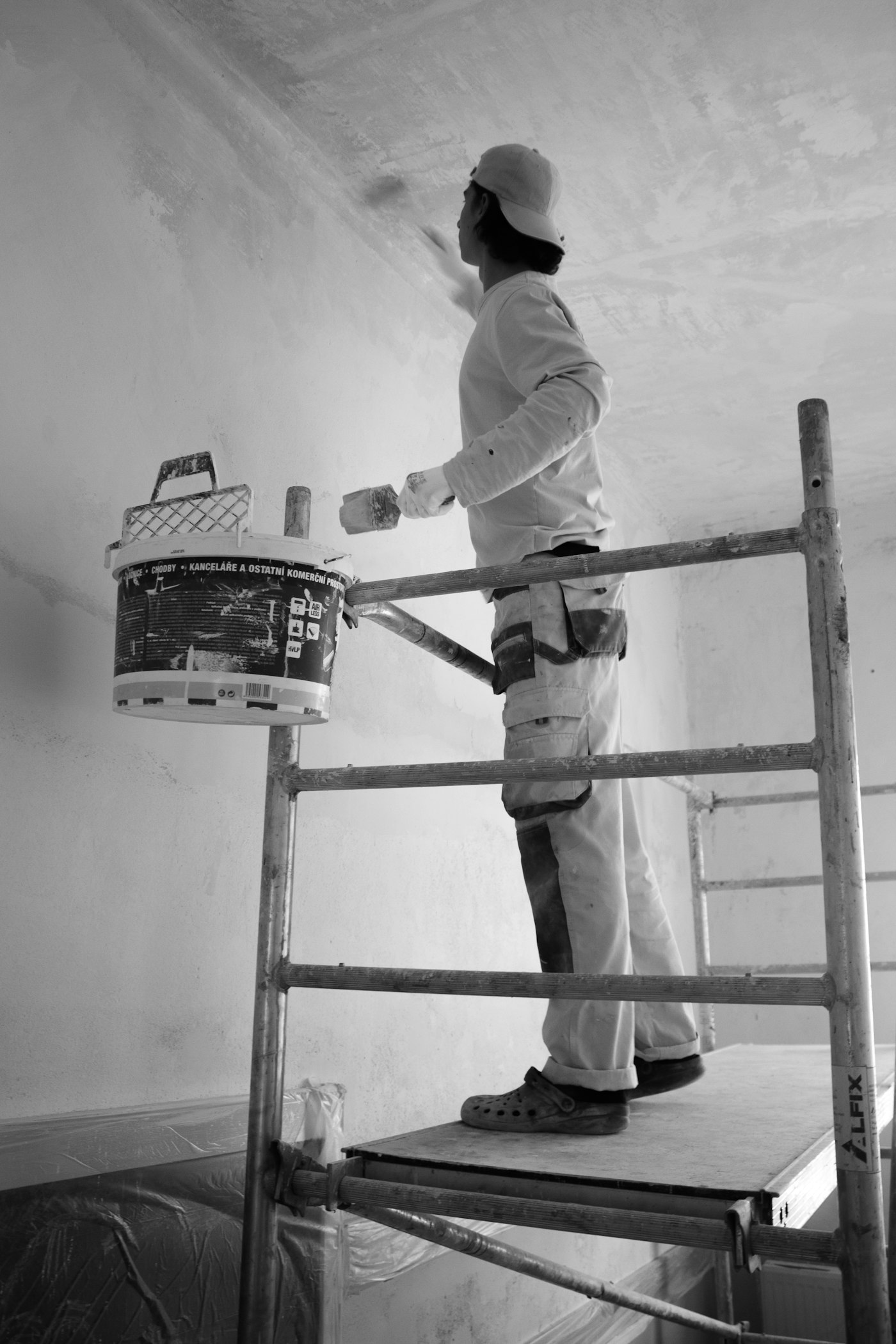 Pintor aplicando tinta na parede com rolo