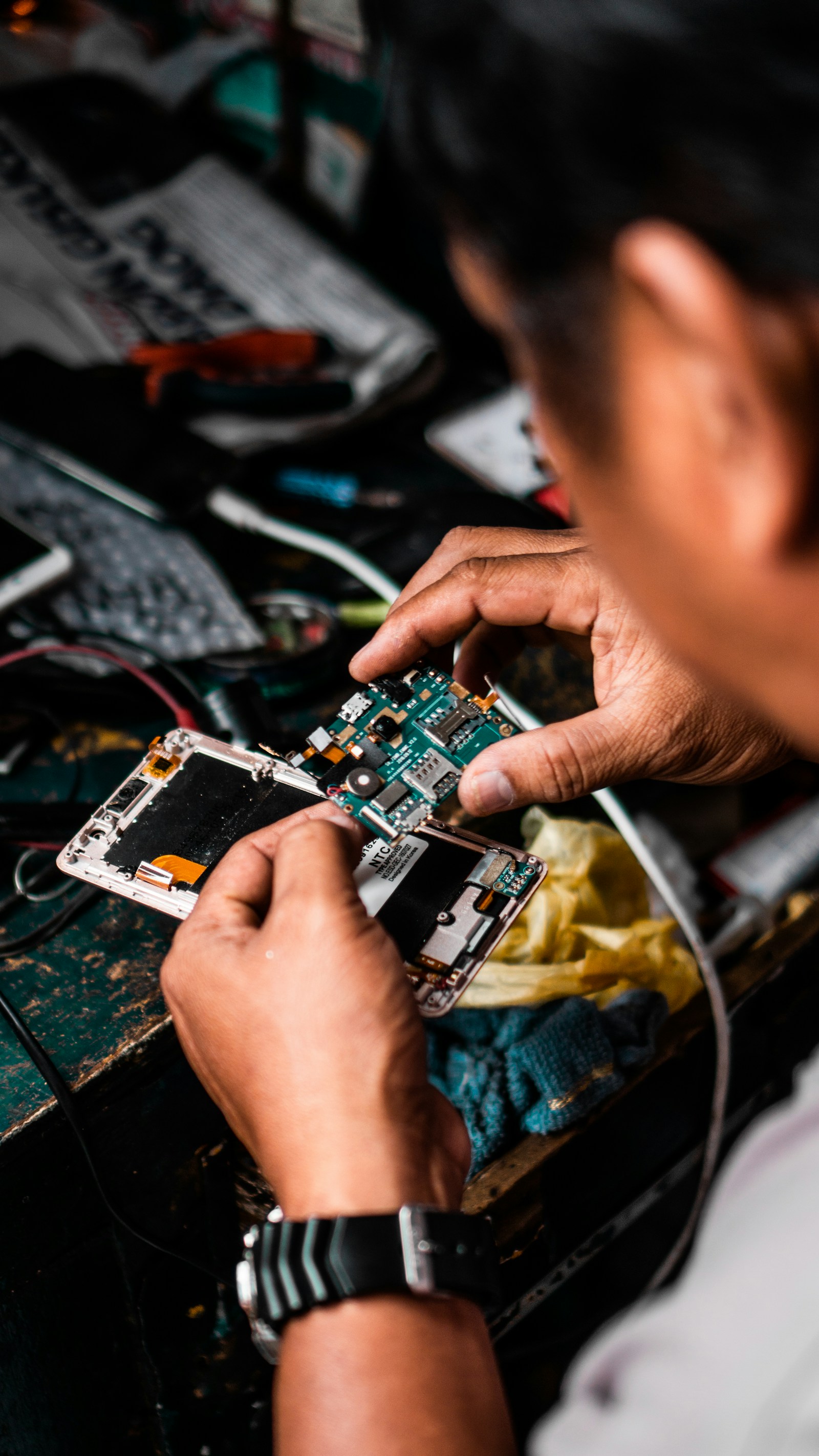 Técnico trabalhando em reparo de celular sem contrato formal